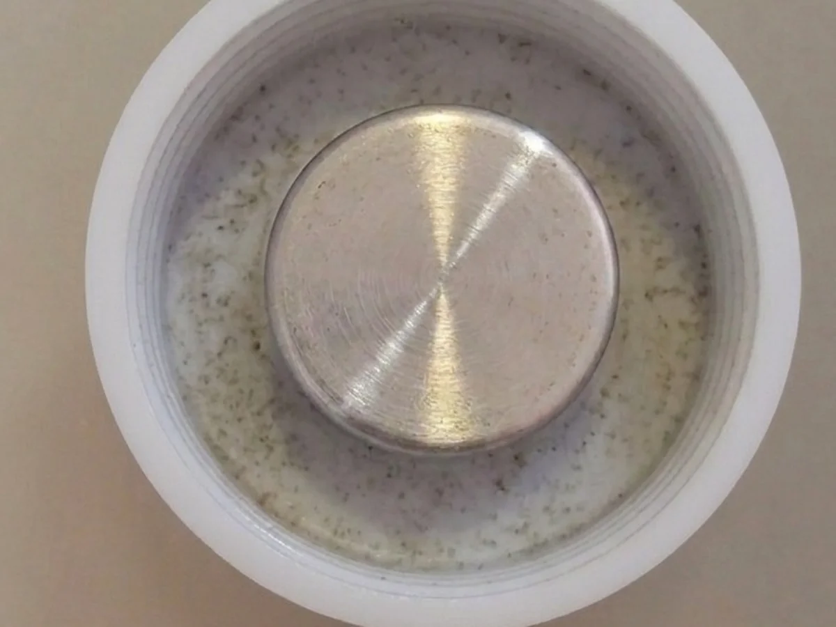 Tappo a vite riutilizzato con evidente contaminazione sotto la guarnizione